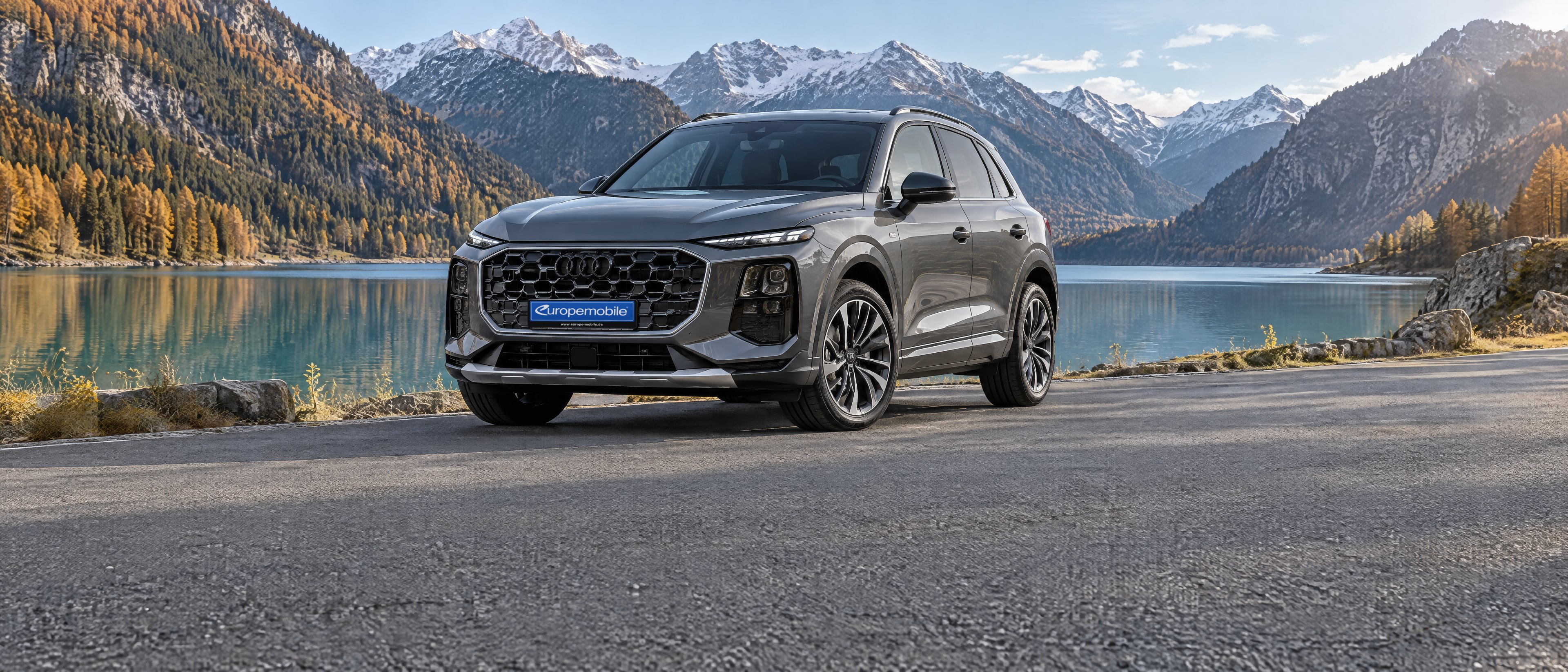 Audi Q3 der dritten Generation in Grau an einer Uferstraße am Bergsee