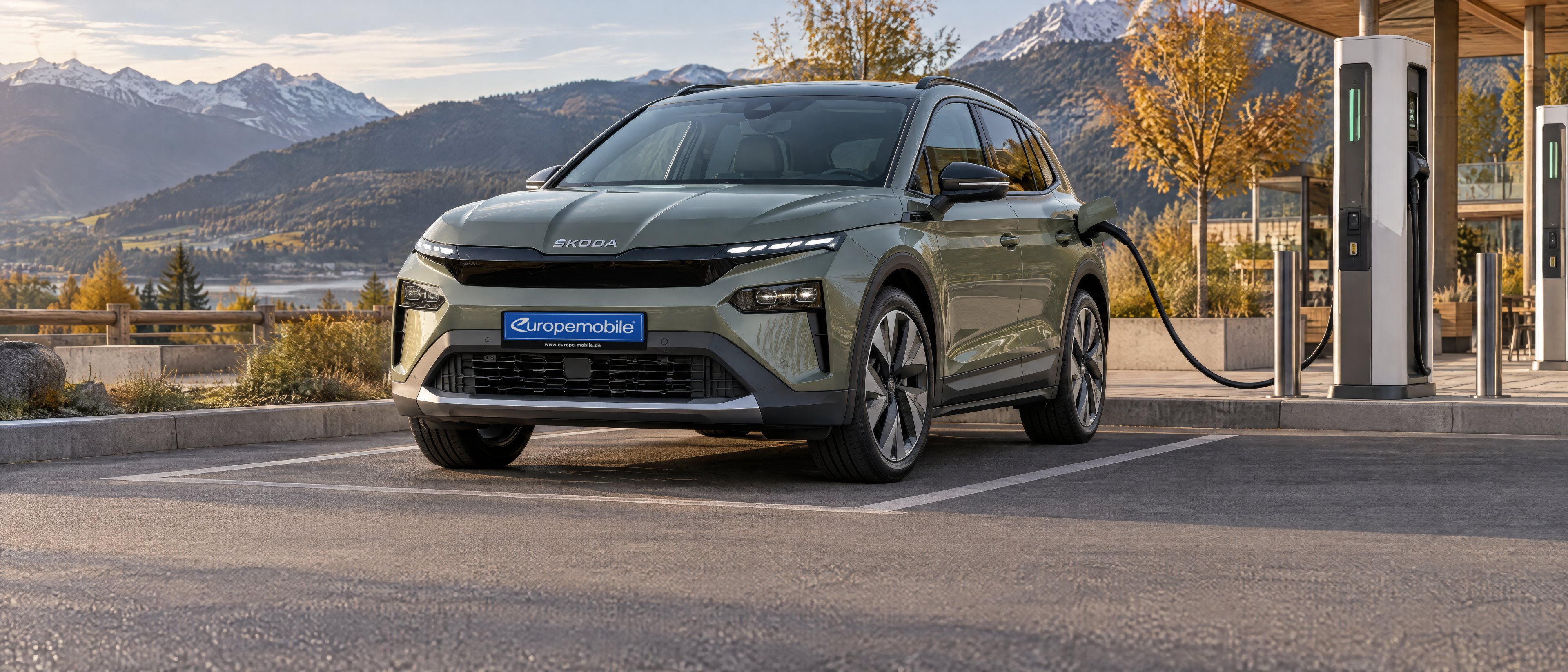 Škoda Elroq in Grün an einer Schnellladesäule vor Alpenkulisse