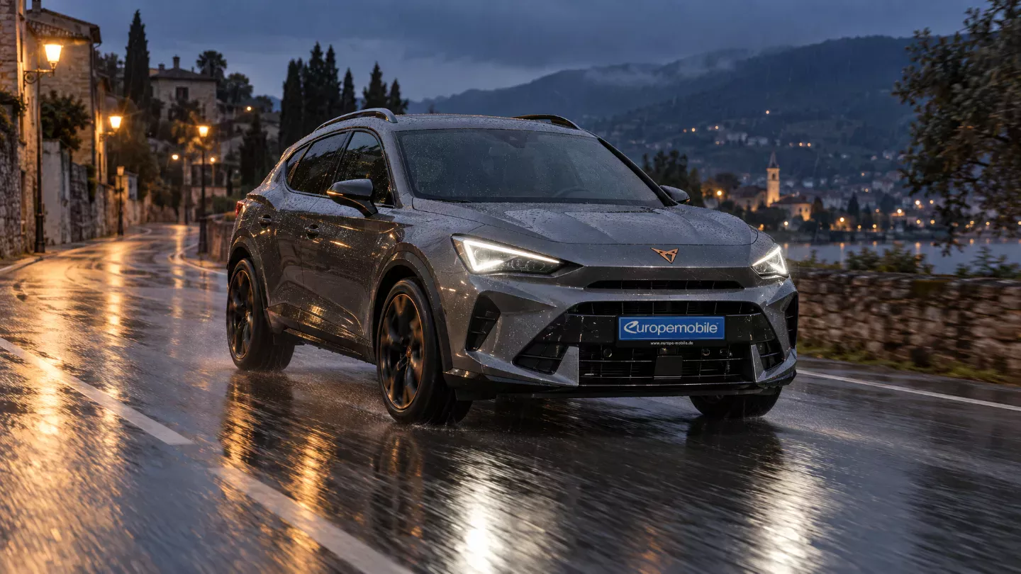 Grauer Cupra Formentor 2026 bei Regen auf einer nassen Straße am Abend, mit Abblendlicht