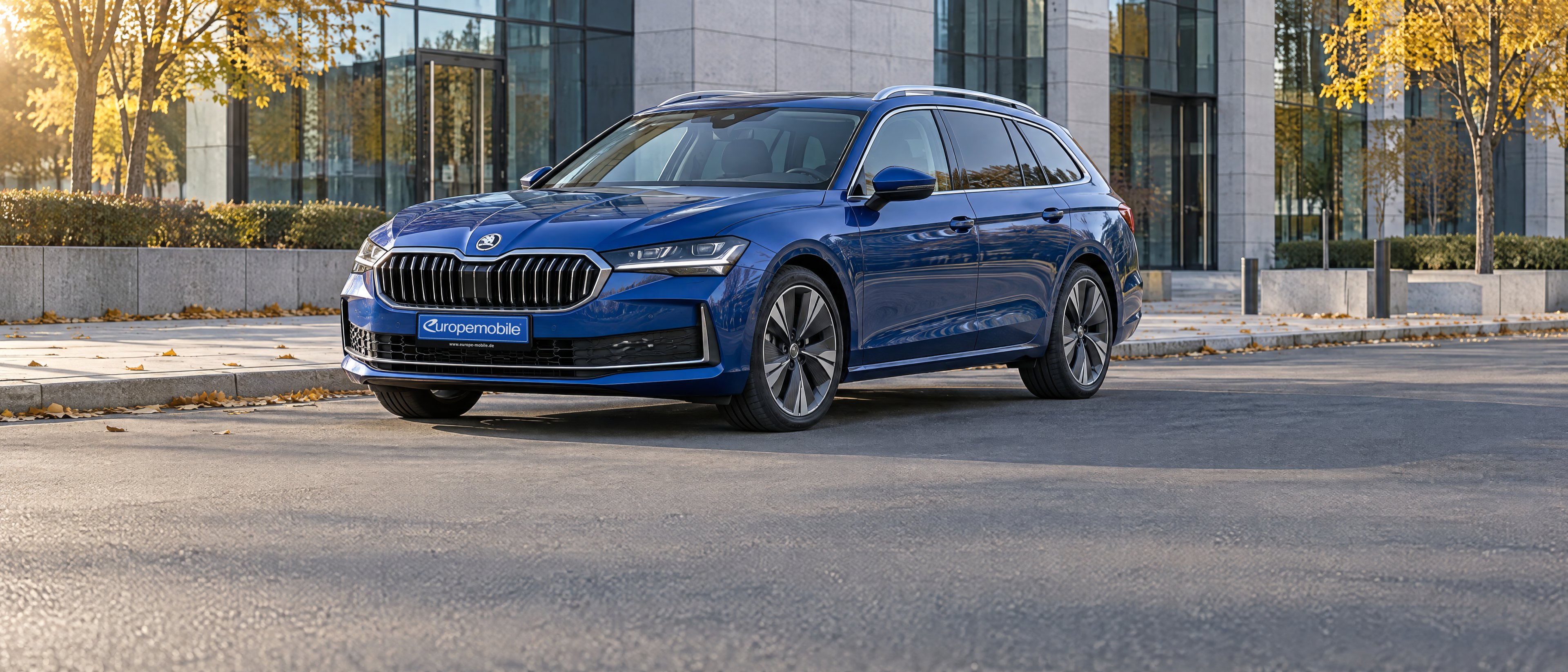 Škoda Superb Combi 2026 in Blau vor einem modernen Bürogebäude im Herbst