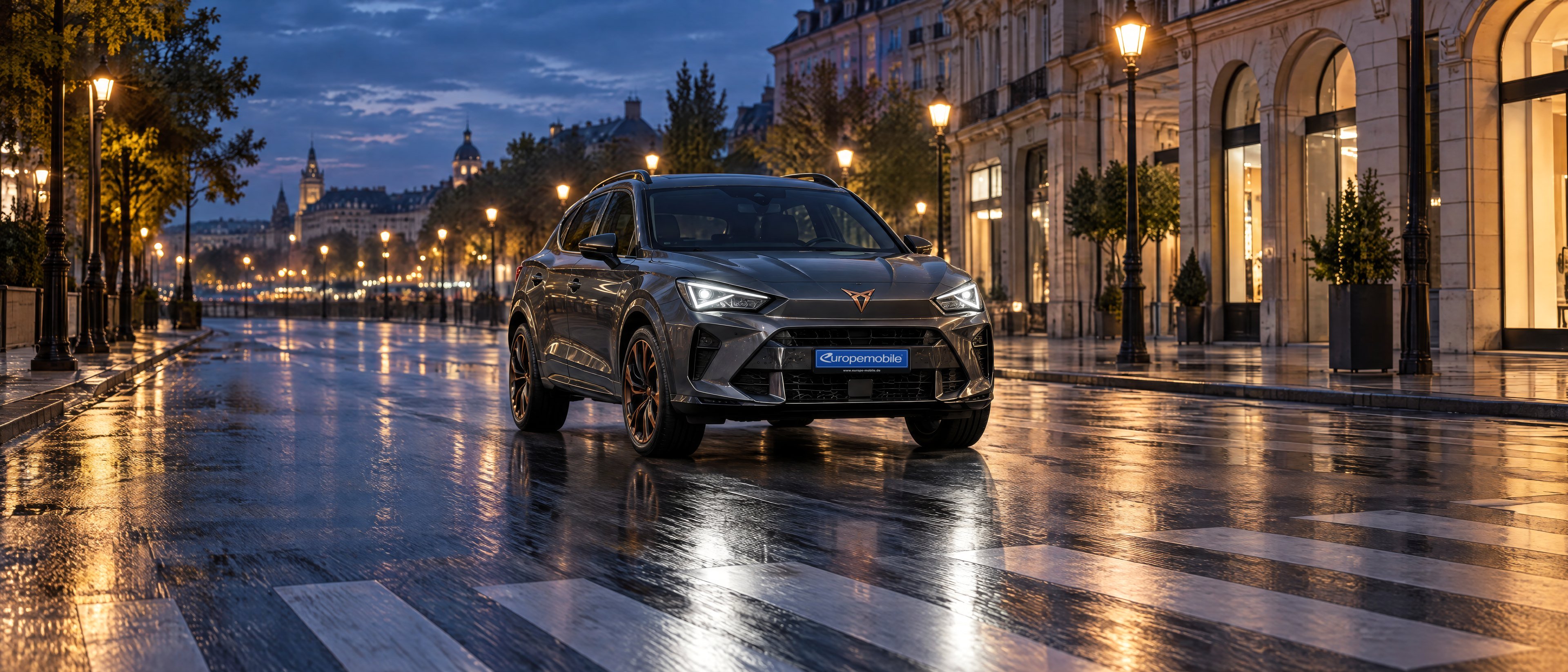 Cupra Terramar in Dunkelgrau mit Abblendlicht auf einem nassen Innenstadt-Boulevard zur blauen Stunde